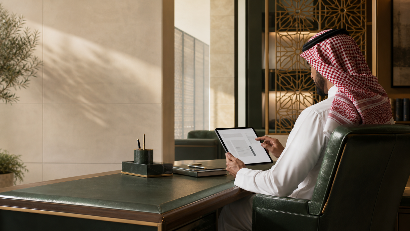محامٍ سعودي يراجع ملفًا قانونيًا رقميًا في مساحة عمل خاصة